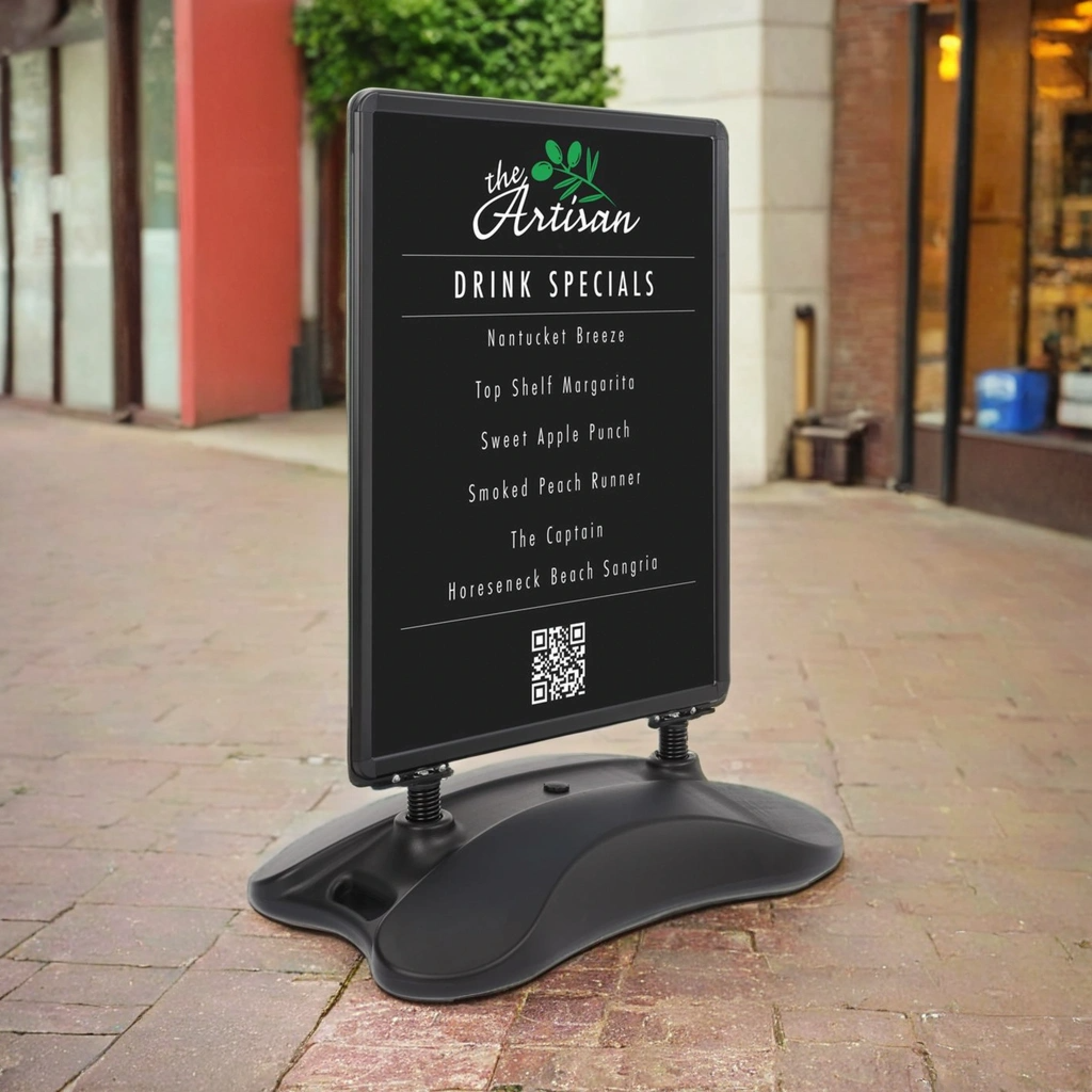 Heavy-duty black A-board pavement sign with a weather-resistant design, displayed in an outdoor retail setting. Suitable for A0 posters, featuring a sturdy frame and stable base. Ideal for high-traffic areas, cafés, and storefront promotions. Branded Displaysense product for professional signage solutions.